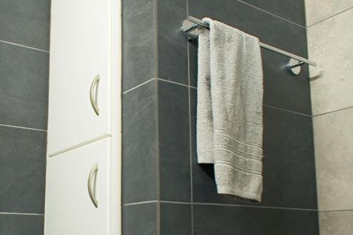 a bathroom with a towel hanging on a wall at ALEX APARTMENT in Strovolos