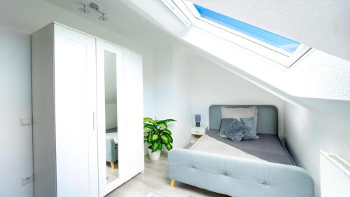 a living room with a blue couch and a skylight at 2,5-Zimmer inkl Arbeitsplatz, WLAN & free Netflix, Amazon-Free Parken vollausgestattete Wohnung, 24h Check In in Hamm