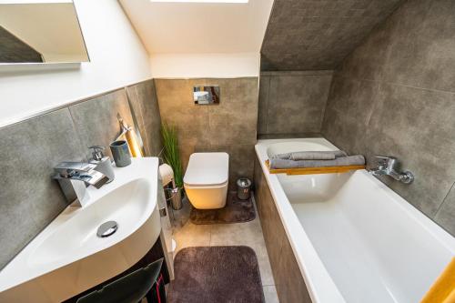 a small bathroom with a tub and a sink at 2,5-Zimmer inkl Arbeitsplatz, WLAN & free Netflix, Amazon-Free Parken vollausgestattete Wohnung, 24h Check In in Hamm