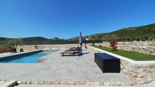 einen Pool mit einer Steinmauer neben einer Steinmauer in der Unterkunft Private Villa Bosilen Marina by Trogir Split airport Sibenik in Marina
