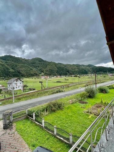 a view of a road with a field and a house at Casa Rus in Leordina
