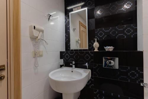 a bathroom with a sink and a mirror at Hotel 19 Batumi in Batumi