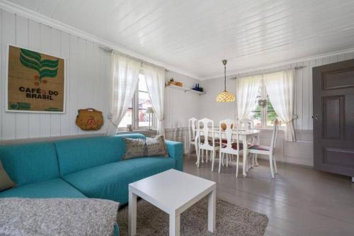 a living room with a blue couch and a table at Veslestua - Beach Bliss & Fishing Fun in Hemnes