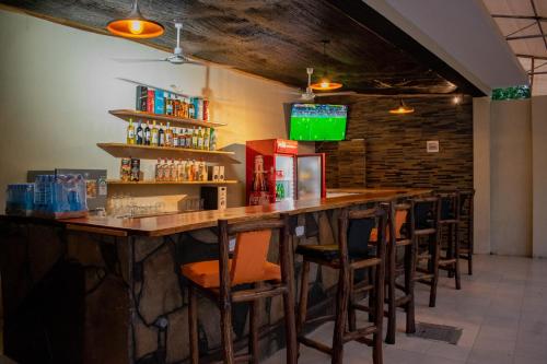 een bar met een rij barkrukken in een restaurant bij Inkaba Resort & Conference Centre Kilifi in Kilifi
