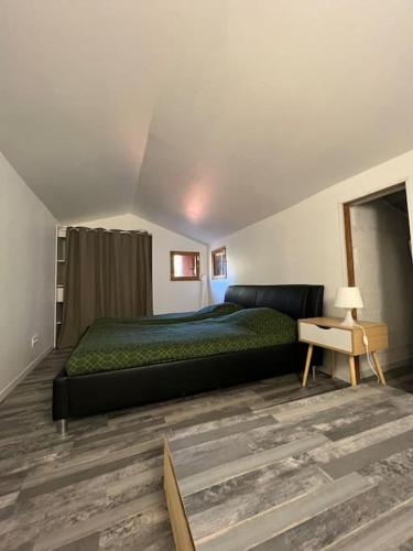 une chambre avec un grand lit et une table dans l'établissement Jolie maison dans village médiéval. Bouchet, à Bouchet