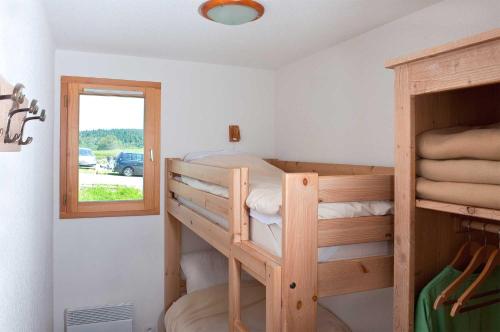 sypialnia z 2 łóżkami piętrowymi i oknem w obiekcie Madame Vacances Les Chalets Du Berger w mieście La Feclaz