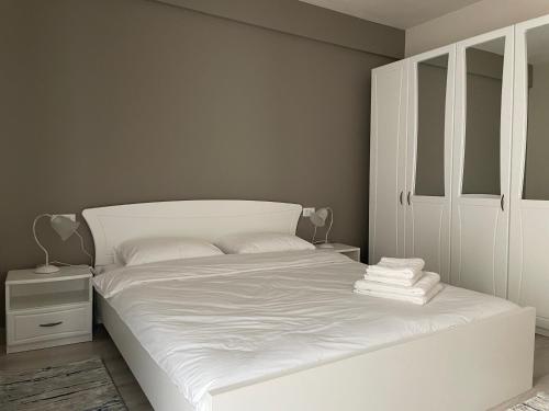 a bedroom with a white bed and a white cabinet at Septimius Severus Apartments in Alba Iulia