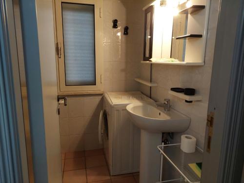 niewielka łazienka z umywalką i oknem w obiekcie Casa Gemma w mieście Orosei