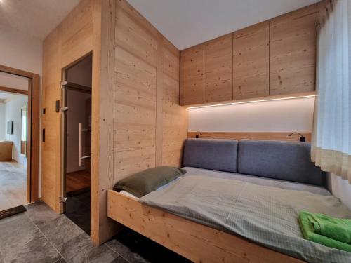 a bedroom with a bed in a wooden wall at Riverside 1st Floor South in Saas-Fee