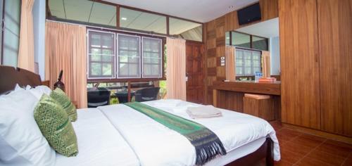 a bedroom with a large white bed and a window at Mountain Resort Koh Lipe in Ko Lipe