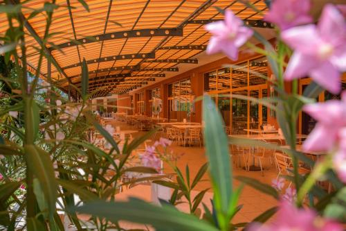 a room with tables and chairs and pink flowers at Atlas Hotel - Free Outdoor Pool and Heated Indoor Pool in Golden Sands