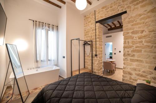 a bedroom with a bed and a stone wall at Apartamentos Loliqui centro Alicante in Alicante