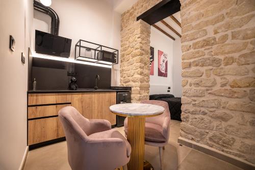 a room with a table and two chairs and a kitchen at Apartamentos Loliqui centro Alicante in Alicante