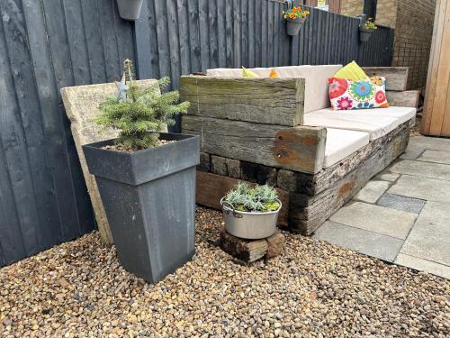 a wooden bench with potted plants on a patio at The Studio by Hip Haus in Cleethorpes