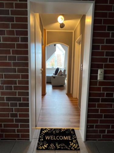 a hallway with a welcome mat in front of a brick wall at Nieman‘s Loft in Emden