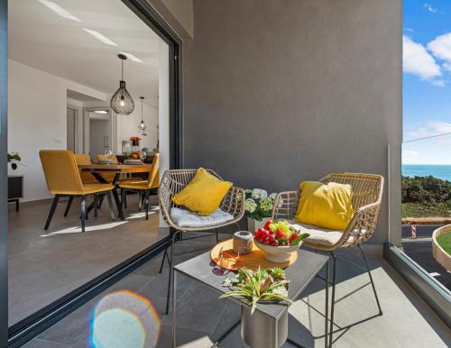 salon z żółtymi poduszkami, stołem i krzesłami w obiekcie Apartment Skyline w mieście Cavtat