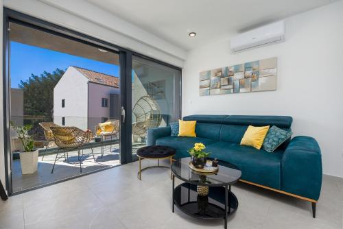 salon z niebieską kanapą i dużym oknem w obiekcie Apartment Skyline w mieście Cavtat