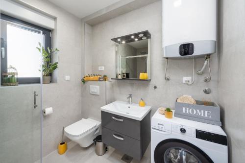 a bathroom with a sink and a washing machine at Apartment Skyline two-bedroom apartment with balcony in Cavtat