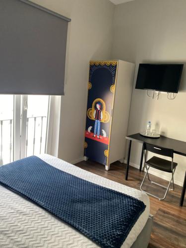 a bedroom with a bed and a table and a desk at Guest House Stories in Beja
