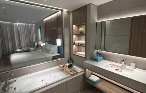 a bathroom with a large mirror and a bath tub at À La Carte Halong Bay in Ha Long