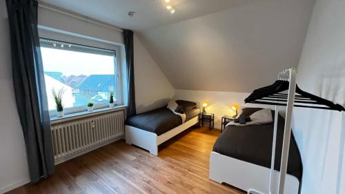 um quarto com 2 camas e uma grande janela em Work & Stay Apartments in Bad Laer em Bad Laer