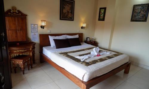 a bedroom with a bed with a stuffed animal on it at Danasari Homestay in Ubud