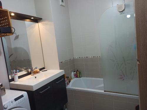 a bathroom with a tub and a sink and a bath tub at Appartement entier Cozy Rdj Parking gratuit, proche tramway, stade OL, ARENA, Eurexpo, Aéroport StExupéry, Gare TGV Lyon Partdieu in Décines-Charpieu