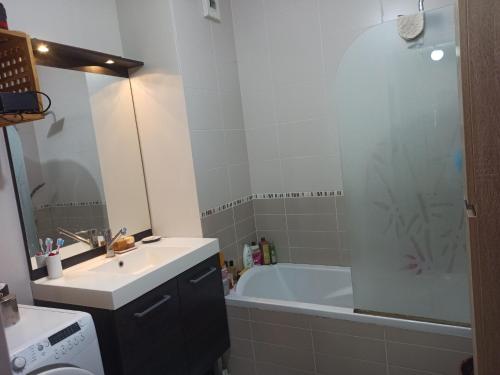 a bathroom with a tub and a sink and a bath tub at Appartement entier Cozy Rdj chambre double proche stade OL, ARENA, Eurexpo, Aéroport StExupéry, Gare TGV Lyon Partdieu in Décines-Charpieu