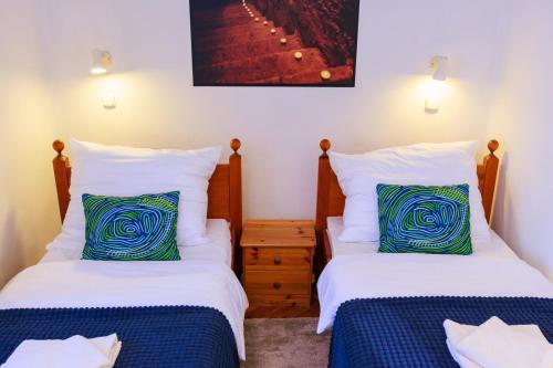 a bedroom with two beds and a night stand at Retel Vitez Vendégház in Sárospatak