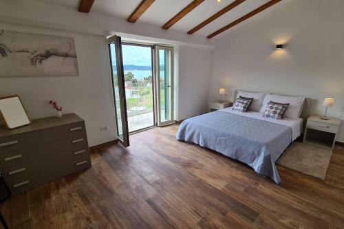 um quarto com uma cama e uma grande janela em Magnificent new Villa Tofta on Lopud, Croatia. Sea views from the infinity pool em Lopud