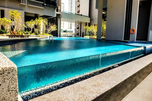 a swimming pool in a building with blue water at Attic Home Melaka Imperio Residence & Jonker in Melaka