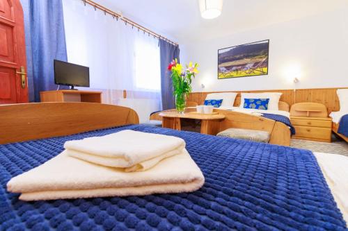 Una habitación de hotel con una cama azul con toallas. en Retel Vitez Vendégház, en Sárospatak