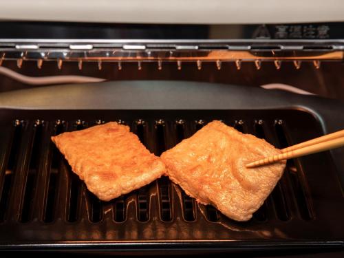 dois pedaços de comida em uma grelha dentro de um forno em Yamatoya Honten em Matsuyama