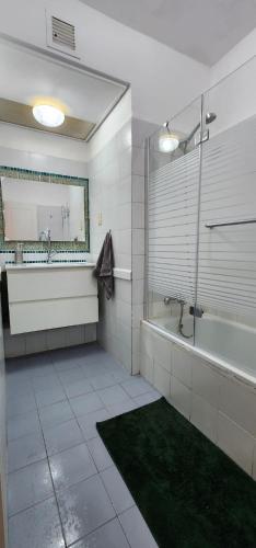 a bathroom with a tub and a shower and a sink at Eilat Octopus Apartment - אילת אוקטופוס -שני חדרים וסלון, בריכה בקיץ in Eilat