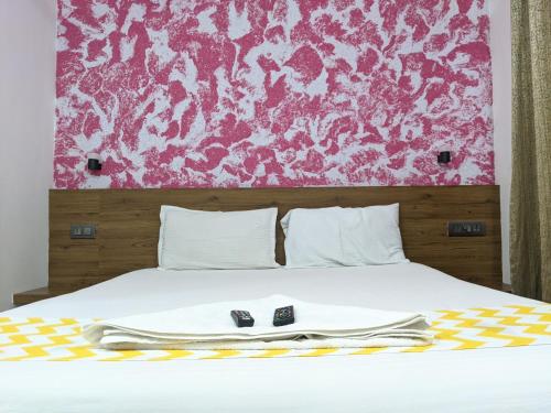a bed with two remote controls sitting on top of it at Cherai Blue View Beach Resort in Cochin