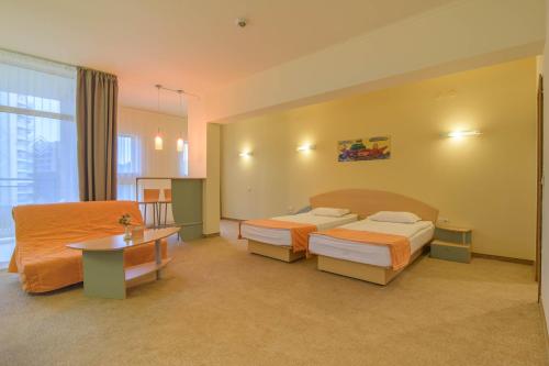 a hotel room with two beds and a table at Atlas Hotel - Ultra All Inclusive in Golden Sands