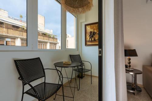 een kamer met 2 stoelen, een tafel en 2 ramen bij Dema's Luxury Suites(E6) in Athene