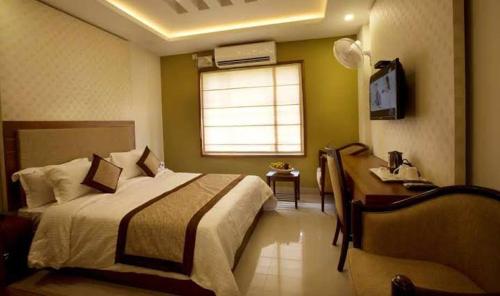 Un dormitorio con una cama grande y una ventana en Rotano Glitz Inn - Glitz Inn Calicut, en Kozhikode