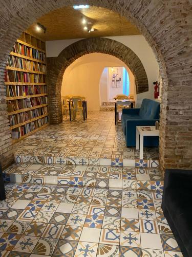 uma sala de estar com piso em azulejo e estantes em Guest House Stories em Beja