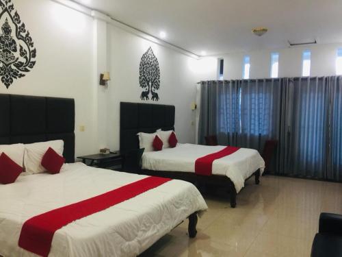 een slaapkamer met 2 bedden met rode en witte lakens bij EZ Guesthouse in Phnom Penh