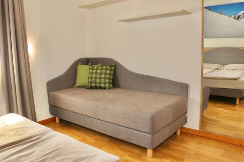 a couch in a room with a bed and a mirror at Appartamenti Forhotel in Livigno