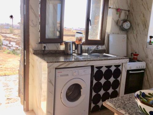 uma cozinha com uma máquina de lavar roupa e um lavatório em Lovely Cottage em La Oliva