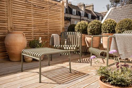 eine Gruppe Stühle und ein Tisch auf einer Terrasse in der Unterkunft The Yard in Bath Hotel in Bath