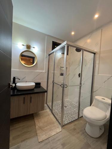 a bathroom with a shower and a toilet and a sink at Apartamentos Orquidea Dorada apt 101 & 104 in Comayagua