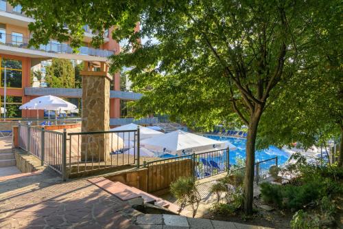 una piscina con mesas y sombrillas junto a un edificio en Atlas Hotel - Free Outdoor Pool and Heated Indoor Pool en Golden Sands