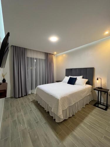 una camera da letto con un letto grande e un tavolo di Apartamentos Orquidea Dorada apt 101 & 104 a Comayagua