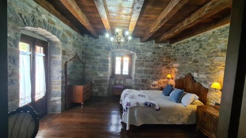 a bedroom with a bed and a stone wall at Txantxorena in Zubiri