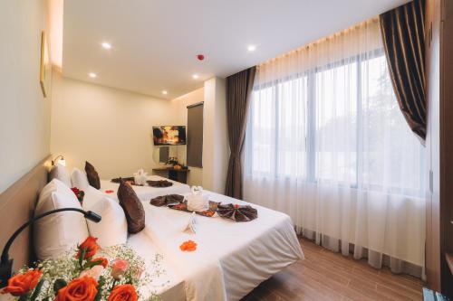 a hotel room with a table with flowers on it at GREENECO DA LAT HOTEL - Khách sạn Green Eco Đà Lạt in Da Lat