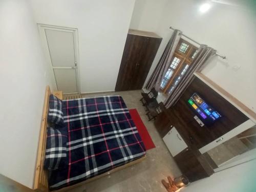 an overhead view of a room with a bed and a door at Travelodge Homestay in Bīr