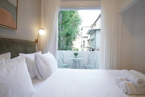 Un dormitorio con una gran cama blanca y una ventana en Bruno 55 By Peraia en Tel Aviv